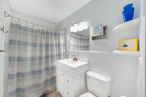 a bathroom with a toilet and a sink and a shower at Beach Apart by Dream Vacation unit 1 in West Palm Beach