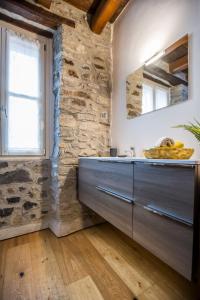a kitchen with a sink and a stone wall at Borgo Molina in Faggeto Lario  +50 photos