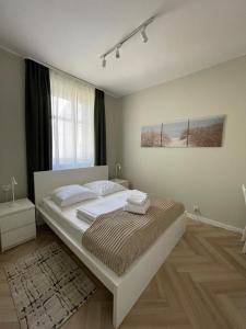 a bedroom with a bed with white sheets and a window at Hotel Miramar in Sopot