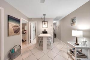 a living room with a white table and a hallway at Beach Apart by Dream Vacation unit 3 in West Palm Beach