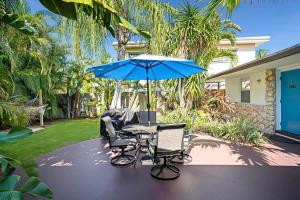 a patio with a table and two chairs and an umbrella at Beach Apart by Dream Vacation unit 3 in West Palm Beach