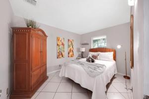 a bedroom with a bed and a wooden cabinet at Beach Apart by Dream Vacation unit 3 in West Palm Beach +15 photos