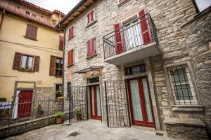 an old stone building with red doors and windows at Borgo Molina in Faggeto Lario 