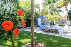 a garden with chairs and a table and flowers at Peacock Villa 2 by Dream Vacation in Fort Lauderdale