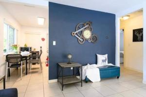 a living room with a blue wall and a dining room at The peacock villa 1 by Dream Vacation in Fort Lauderdale
