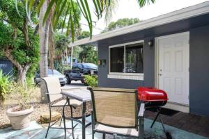 a patio with chairs and a table and a house at The peacock villa 1 by Dream Vacation in Fort Lauderdale