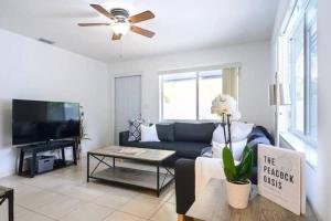 a living room with a couch and a tv at The peacock villa 1 by Dream Vacation in Fort Lauderdale