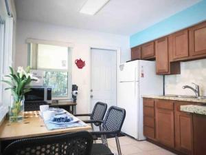 a kitchen with a table and chairs and a white refrigerator at The peacock villa 1 by Dream Vacation in Fort Lauderdale +14 photos