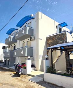 a white building with a scooter parked in front of it at Marika Apartments in Mastihari