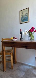a wooden table with a bottle of wine and flowers on it at Marika Apartments in Mastihari