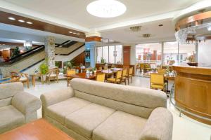 a living room with a couch and a restaurant at Rex Hotel Vung Tau in Vung Tau