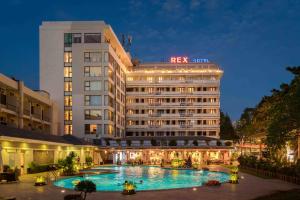 a hotel with a swimming pool in front of a building at Rex Hotel Vung Tau in Vung Tau