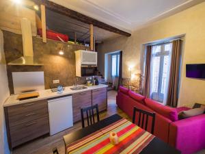 a living room with a red couch and a kitchen at El Mercadal in Cardona