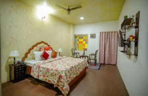 a bedroom with a bed and a table and chairs at Zero Amer Royal Farm Stay in Jaipur