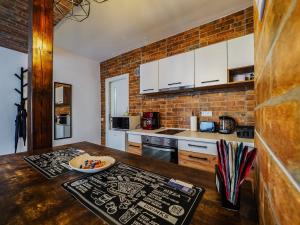 a kitchen with a wooden table and a brick wall at Ben Apartments Near City Center in Sibiu