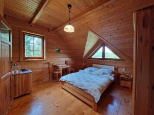a bedroom with a bed in a wooden cabin at Pokoje Gościnne u Laskowskich in Smerek