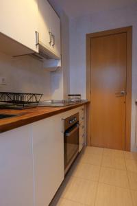 a kitchen with white cabinets and a wooden door at Soldeu Paradis Clos in Soldeu +14 photos