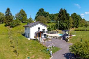 an aerial view of a small white house with a playground at 4 bedroom home Sigma in Zlatar