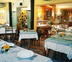 a dining room with tables and chairs with blue tablecloths at Hotel Numi & Medusa in Cesenatico