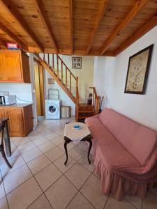 a living room with a couch and a kitchen at Sidirounda Traditional House 1 in Sidiroúnta