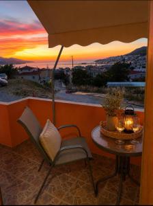 a table and chairs on a balcony with a sunset at Casa Polyxeni -Elegant Stay in Vathi in Samos +1 photo