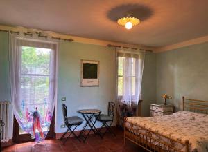 a bedroom with a bed and a table and chairs at La Madonnina Agriturismo Dorè in Alba