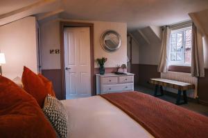 a bedroom with a bed and a window and a mirror at Boot & Shoe in Flintham