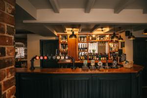 a bar in a pub with a lot of alcohol at Boot & Shoe in Flintham