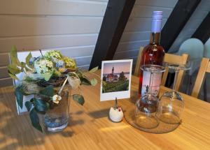 a bottle of wine and a vase of flowers on a table at Bodenseehäusle in Immenstaad am Bodensee