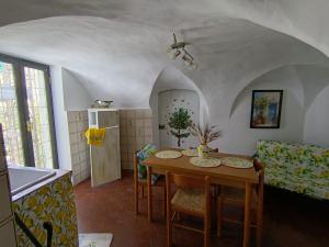 a living room with a table and a kitchen at Limonaia in Villa Viani
