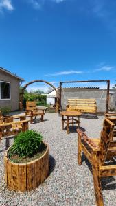 a group of wooden benches sitting in a patio at Keremet Yurt in Bokonbayevo +21 photos