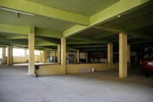 an empty parking garage with a car parked in it at Hotel Vista by Booksy One Kollam Near Kollam Bypass in Kollam