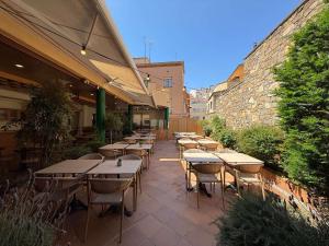 eine Reihe von Tischen und Stühlen auf einer Terrasse in der Unterkunft Hostal ROM Familiar in Roses