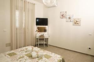 a bedroom with a bed and a desk and a television at La Rosa di Antonio & Relax Room in Tricase