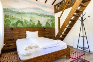 a bed in a room with a painting on the wall at Carpatia Retezat in Clopotiva