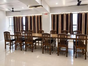 a dining room with a wooden table and chairs at Hotel Apollo Sp Ring Road Odhav Ahemdabad in Ahmedabad