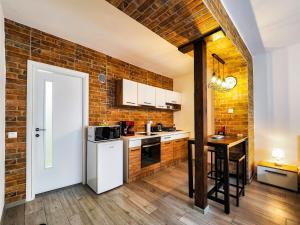 a kitchen with a brick wall and a white refrigerator at Ben Apartments Near City Center in Sibiu