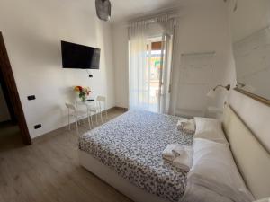 a white bedroom with a bed and a tv at B&B 10 mt dal duomo in Benevento