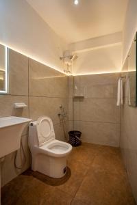 a bathroom with a white toilet and a sink at Hotel Vista by Booksy One Kollam Near Kollam Bypass in Kollam
