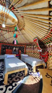 a large room with two beds and a table at Keremet Yurt in Bokonbayevo