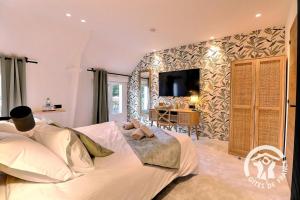 a bedroom with a large bed and a tv on the wall at Rozen in Roz-Landrieux