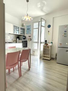 a kitchen with a table and a refrigerator at Perfect Wave a 10 m dal mare in Sanremo