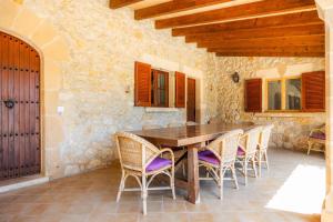 a dining room with a wooden table and chairs at Villa Cal Apostol in Pollença