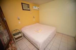 a bedroom with a bed with a book on it at Hotel Lilian in Puerto Iguazú