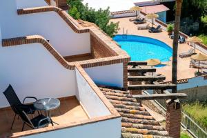 a house with a swimming pool and stairs next to it at Hotel Rural Almazara in Frigiliana