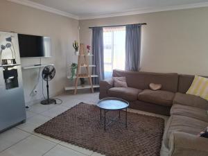 a living room with a couch and a table at CE Guesthouse in Vanderbijlpark