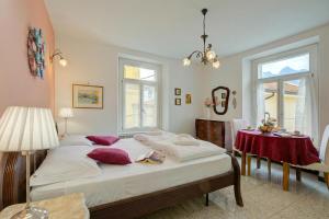 a bedroom with a bed and a table with a red table cloth at Vida Boa Apartments in Nago-Torbole