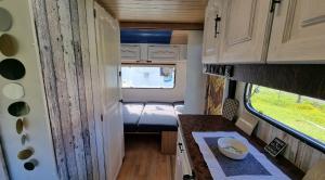 an interior view of an rv with a table and a window at Camping Erzhütte in Rechenberg-Bienenmühle