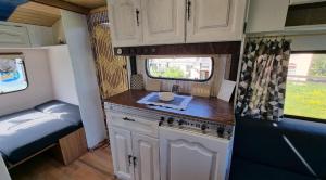 a kitchen in an rv with a sink and a bed at Camping Erzhütte in Rechenberg-Bienenmühle
