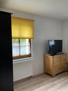 a room with a tv on a dresser and a window at Ferienwohnung Haubitz in Borna